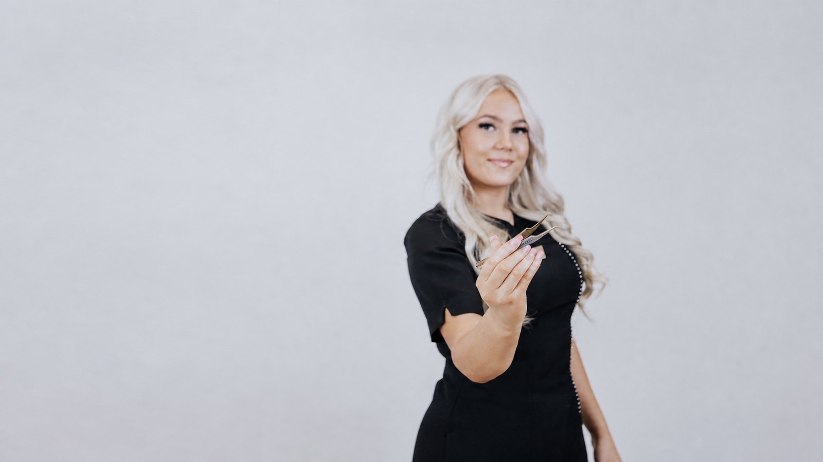 Henni studiolla ripsipinsetit kädessään